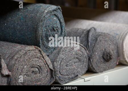 Covering non-woven material in rolls on the shelves of the warehouse. Stocks of cloth and rags. Copy space Stock Photo