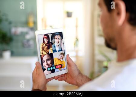 Unrecognizable man having video call on tablet at home. Stock Photo