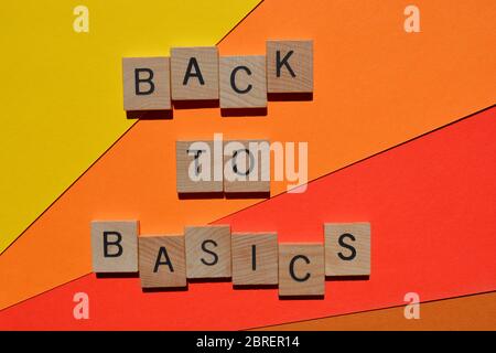 Back to Basics in wooden alphabet letters  isolated on orange and red background Stock Photo