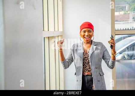 young black businesswoman feeling excited and happy celebrating while holding her mobile phone Stock Photo