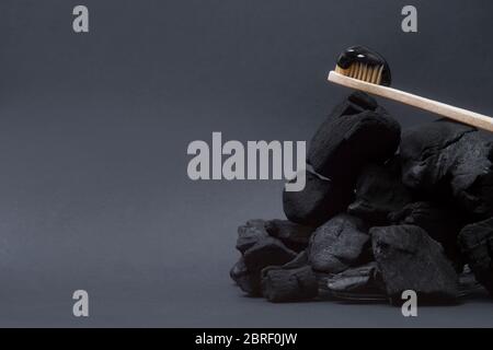 Natural toothpaste activated charcoal and bamboo toothbrush on black  background. Zero waste concept. Stock Photo