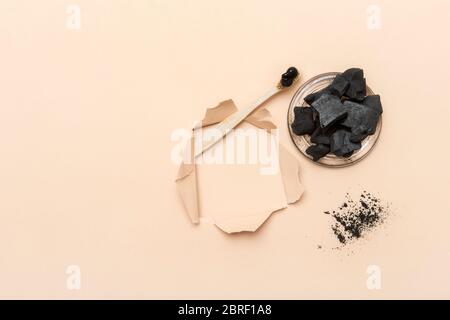 Natural toothpaste activated charcoal in glass jar and bamboo toothbrush on camel color background. Zero waste concept. Stock Photo