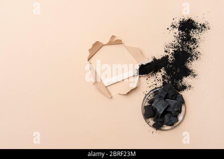 Natural toothpaste activated charcoal in glass jar and bamboo toothbrush on camel color background. Zero waste concept. Stock Photo