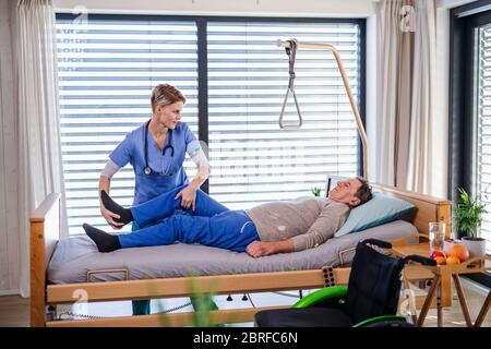 A healthcare worker and senior patient in hospital, physiotherapy. Stock Photo