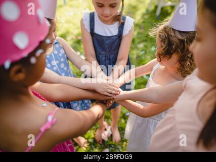 Children playing outdoors on birthday party in garden in summer.