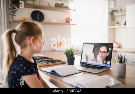 Small girl learning through internet indoors at home, Corona virus and quarantine concept. Stock Photo