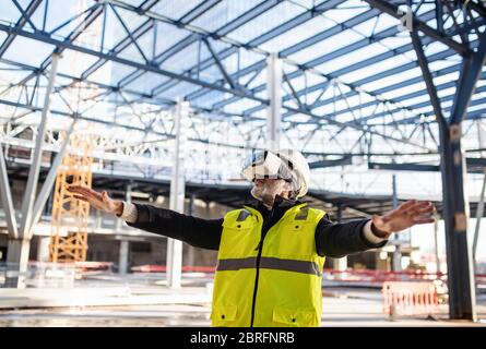 Man engineer using VR goggles on construction site. Stock Photo