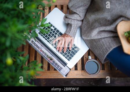 Top view of senior woman with laptop sitting outdoors on terrace, working. Stock Photo