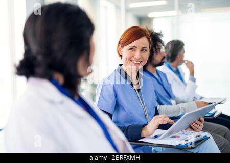 Group of doctors with tablet on medical conference, talking. Stock Photo