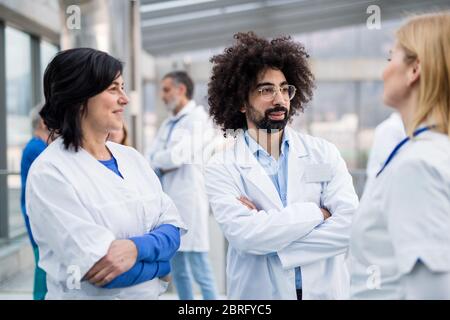 Group of doctors standing in corridor on medical conference. Stock Photo