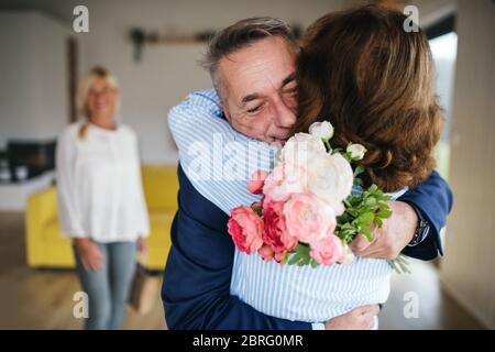Group of senior friends at dinner party at home, greeting. Stock Photo