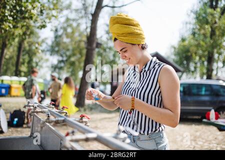Young woman at summer festival, washing in the morning. Stock Photo