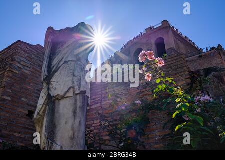 The sun peaks out from behind an ancient statue in the Roman Forum, Rome, Italy Stock Photo