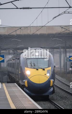 Class 395 high speed passenger train in Southeastern livery arriving at a railway station on a foggy day in England. Stock Photo