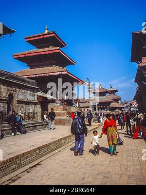 Nepal, Kathmandu. Coulrful street scenes in the medieval Durbar Square of Patan looking towards the memorial column to King Yoganarendra Malla and Shiva Temple Stock Photo
