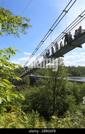 21 May 2020, Saxony-Anhalt, Rübeland: Visitors walk on the suspension bridge Titan RT near the Rappbode dam. Bright sunshine again attracted many guests to the Harz Mountains. After further loosening, the structure could now be released for visitor traffic again in compliance with the statutory hygiene regulations. The bridge has an approximately 458 meter long freely suspended area. From there, one has a view of the 106-metre high Rappbode dam at the entrance to the Bodetal. Photo: Matthias Bein/dpa-Zentralbild/ZB Stock Photo