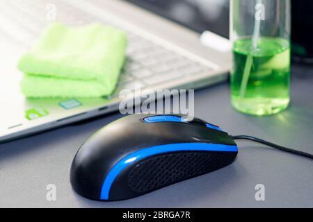 Computer mouse and bottle of sanitizer and a laptop on the desktop in the office. Prevention and control of coronavirus infection and other viral Stock Photo