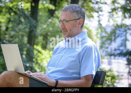 Businessman working with his laptop computer in the park Stock Photo