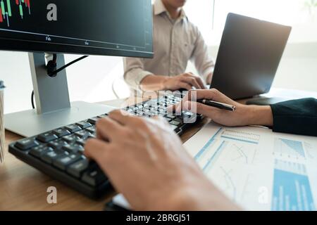 Working business man, team of broker or traders talking about forex on multiple computer screens of stock market invest trading financial graph charts Stock Photo