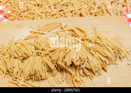 Homemade pasta made from wholesome whole wheat flour on a cutting board. Stock Photo