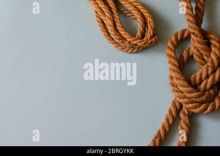 Marine subjects, boating, travel and vacation background. Natural ropes on a light blue background. A variety of twisted hemp ropes. View from above. Stock Photo