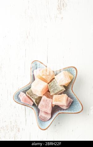 colorful assortment of Turkish delights in a star shaped plate on a wooden table Stock Photo