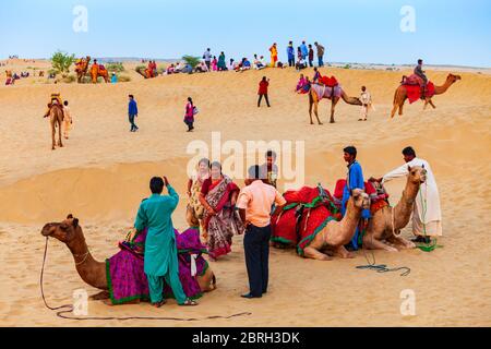 JAISALMER, INDIA - OCTOBER 13, 2013: Unidenfified people and camels at safari in Thar desert near Jaisalmer city in India Stock Photo
