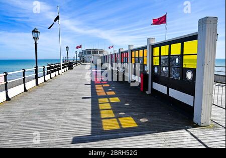 Worthing UK 21st May 2020 - The coloured art windows reflect on to the decking of Worthing Pier which is open again to the public during lockdown through the Coronavirus COVID-19 pandemic crisis . It has been another hot day throughout Britain with temperatures reaching the high 20's again in some parts . Credit: Simon Dack / Alamy Live News Stock Photo