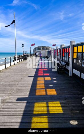 Worthing UK 21st May 2020 - The coloured art windows reflect on to the decking of Worthing Pier which is open again to the public during lockdown through the Coronavirus COVID-19 pandemic crisis . It has been another hot day throughout Britain with temperatures reaching the high 20's again in some parts . Credit: Simon Dack / Alamy Live News Stock Photo