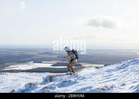 A off piste skier skiing down East Lomond Hill, Fife, Scotland Stock Photo