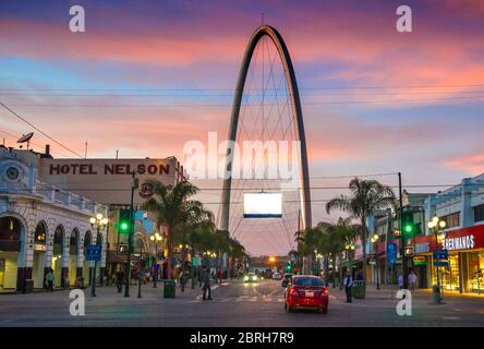 Avenida Revolucion (Revolution street) with the millennial arch (el arco y reloj monumental) at dusk. Tijuana, Mexico Stock Photo