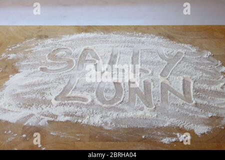 The word Sally Lunn bread written in flour on chopping board, writing in flour Sally Lunn Stock Photo