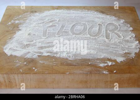 The word flour written in flour on chopping board, writing in flour Stock Photo