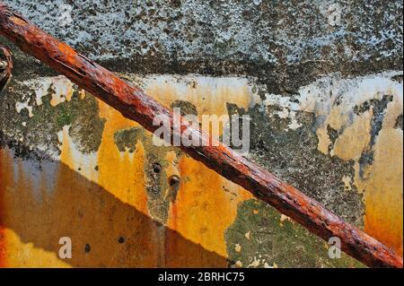 Old handrail attached to exterior weathered wall covered in rust stains Stock Photo