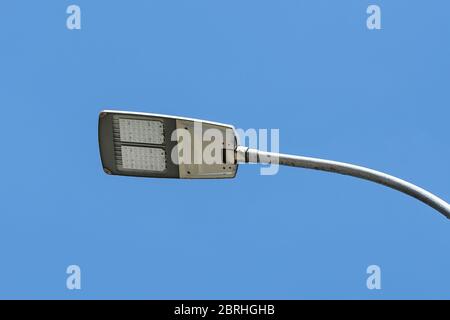 Led streetlight against clear blue sky background. Modern energy-saving technologies for lighting streets and roads. Led street lamp. Low angle view. Stock Photo
