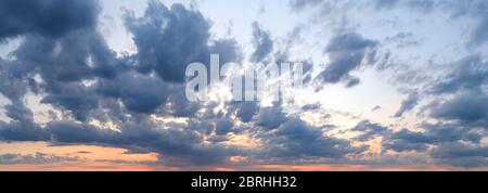 Dramatic sunset sky panorama. Gray blue stormy clouds covering an orange sunset heaven afterglow. Scenic skyscape just after sundown. Beauty in nature Stock Photo