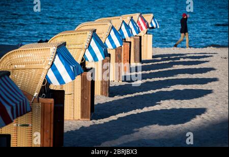 21 May 2020, Schleswig-Holstein, Lübeck-Travemünde: Beach chairs cast long shadows on the beach at the Baltic Sea in the evening. Photo: Daniel Bockwoldt/dpa Stock Photo