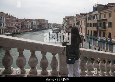 VENICE, ITALY - MAY: Tourists take pictures from Rialto Bridge on May 18, 2020 in Venice, Italy. Restaurants, bars, cafes, hairdressers and other shop Stock Photo