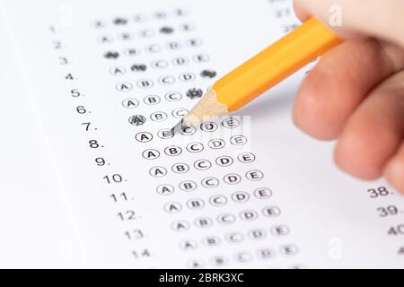 hand fill in Exam papers sheet and pencil. Take the exam, write the exam. Stock Photo
