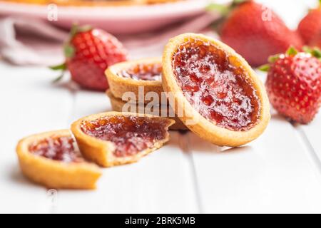 Sweet biscuits with strawberries jam and strawberries on white table. Stock Photo