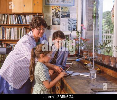 Children using bunsen burner in science class, Surrey, England, United Kingdom Stock Photo