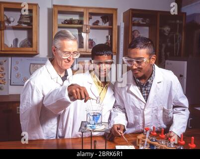 Asian students doing chemical experiments in science class, Surrey, England, United Kingdom Stock Photo