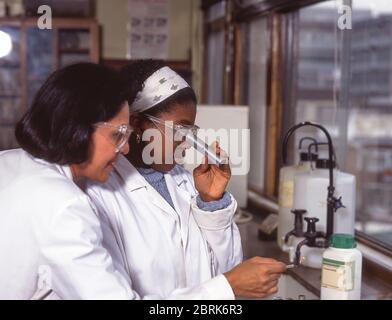 Black student and teacher doing chemistry experiment in science class, Surrey, England, United Kingdom Stock Photo