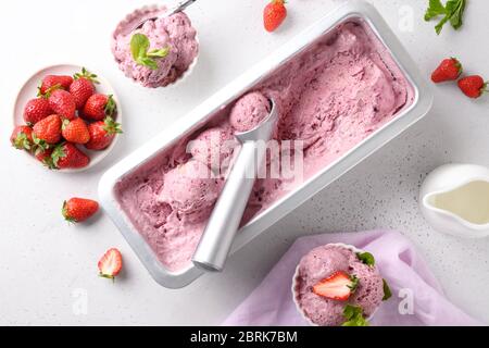 Homemade strawberry ice cream in bowls on white background. View from above. Space for text. Clean eating. Without sugar. Stock Photo
