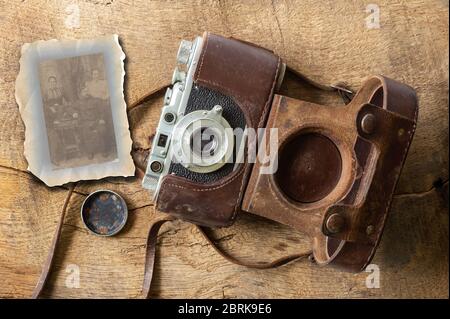Collage of ancient old vintage film camera with old lether cover on brown old wood backgroundand and sepia photo. Antique, vintage, grunge, classic concept Stock Photo