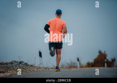 Well built middle aged athlete during a running exercise Stock Photo