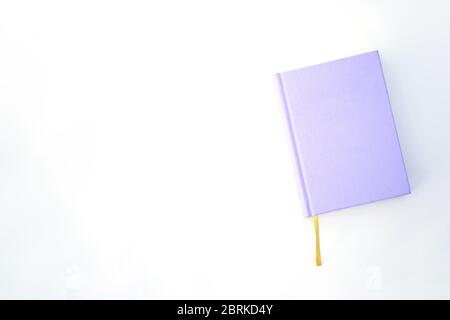 Purple notebook or book on the bright background with the yellow ribbon mockup Stock Photo
