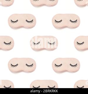 Seamless pattern from pink sleep mask with closed eyes embroidered on it with eyelashes isolated on white background. Photographic collage. Top view, Stock Photo