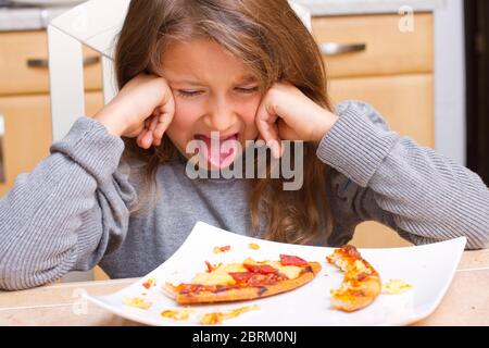 Kind vor Teller mit Pizzaresten, MR: Yes Stock Photo