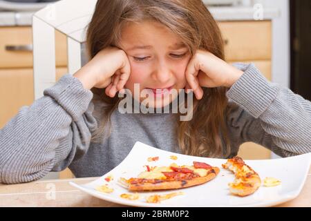 Kind vor Teller mit Pizzaresten, MR: Yes Stock Photo